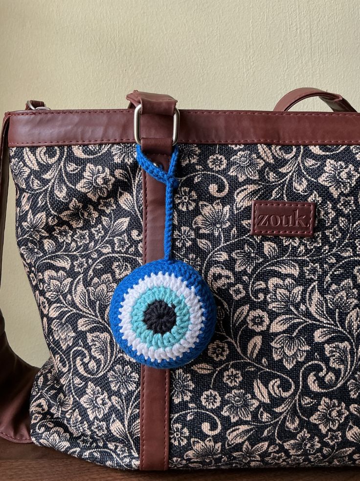 Evil eye bag charm as well as this is functional too you can carry your earpods or coins in it